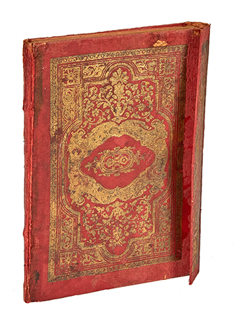 an ancient book with a red and gold cover