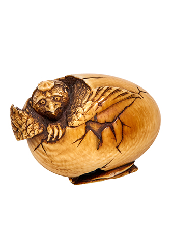a japanese netsuke of a dragon hatching from an egg