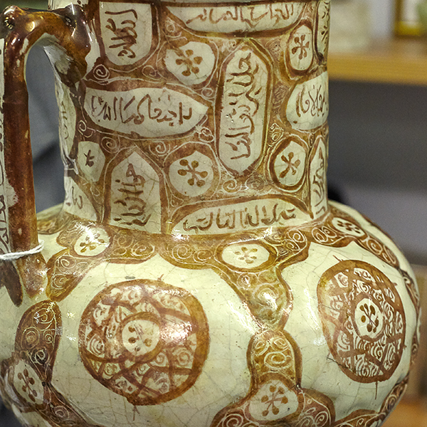 close up of brown and white Islamic jug