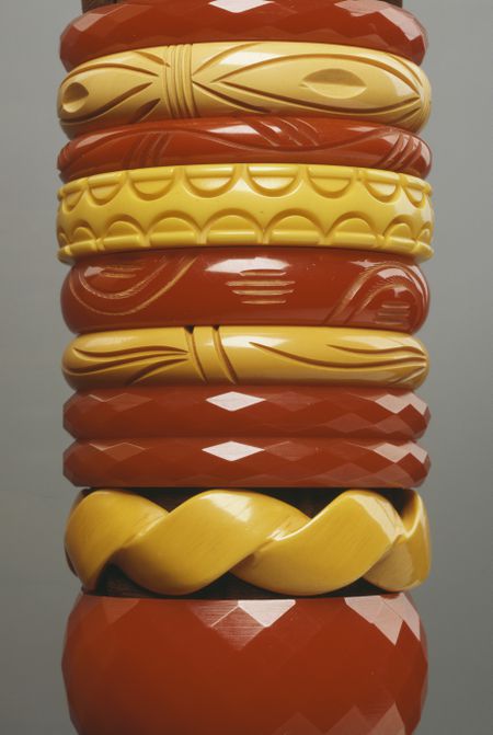 a stack of yellow and orange bakelite jewellery